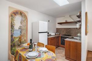 a kitchen with a table and a kitchen with a refrigerator at Il Giardino del Sole, Chalet Salvia in Garlenda