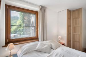 a bedroom with a white bed and a window at Il Giardino del Sole, Chalet Salvia in Garlenda +12 photos