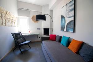 a living room with a couch and a chair at C-Home Historic House in Otranto