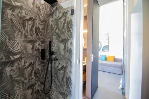 a bathroom with a shower with a leafy wallpaper at C-Home Historic House in Otranto +27 photos