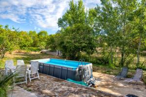 a swimming pool with chairs and a table at La Trêve in La Tour-sur-Orb