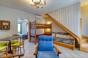 a room with a bunk bed and a table and chairs at La Trêve in La Tour-sur-Orb +27 photos