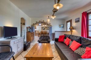a living room with a couch and a tv at La Trêve in La Tour-sur-Orb