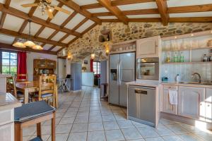 a kitchen with stainless steel appliances and a table at La Trêve in La Tour-sur-Orb