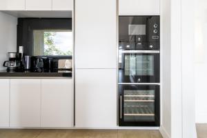a kitchen with white cabinets and a refrigerator at Dalt Son Morro in Santa Margalida