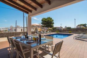 a patio with a table and chairs and a pool at Anglesos in Can Picafort