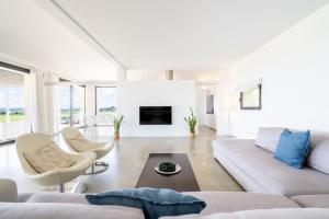 a white living room with a couch and chairs at Dalt Son Morro in Santa Margalida