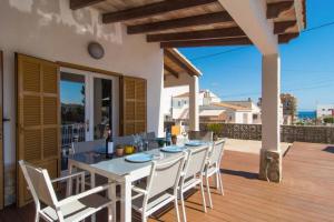 a white table and chairs on a wooden deck at Anglesos in Can Picafort