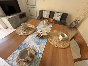 a living room with two wooden tables and two chairs at Essenedda Holiday Home in Orosei