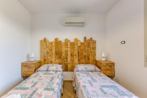 two beds in a room with wooden walls at Villetta La Pajara in Morciano di Leuca