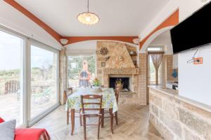 a dining room with a table and a fireplace at Villetta La Pajara in Morciano di Leuca