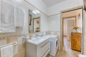 a bathroom with a white sink and a washing machine at Villetta La Pajara in Morciano di Leuca +21 photos