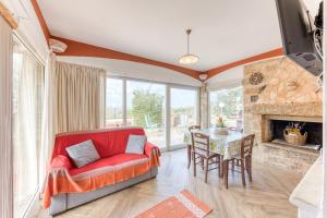 a living room with a red couch and a table at Villetta La Pajara in Morciano di Leuca