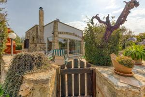 a house with a wooden fence in front of it at Villetta La Pajara in Morciano di Leuca