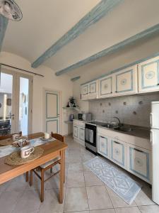 a large kitchen with a table and a counter top at Essenedda Holiday Home in Orosei