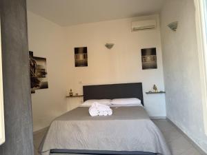 a bedroom with a bed with towels on it at Essenedda Holiday Home in Orosei