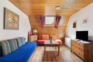 a living room with a blue couch and a tv at Apartmenthaus Ferienwohnungen Sila in Weinstadt