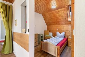 a small bedroom with a bed and a wooden wall at Apartmenthaus Ferienwohnungen Sila in Weinstadt