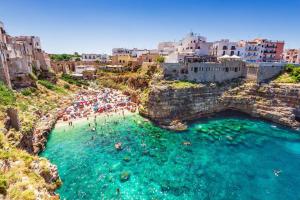 an aerial view of a beach with people in the water at Tritone 30 in Polignano a Mare