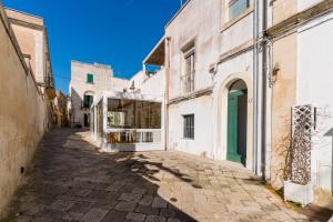 an alley in an old town with a green door at Bacchus Historic Home in Otranto