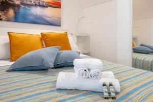 a bed with two towels and two pairs of slippers at Tritone 30 in Polignano a Mare