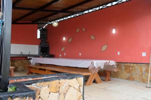 a table in a room with a red wall at Refúgio Paraíso in Santo Amaro