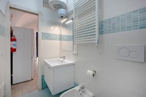 a white bathroom with a sink and a toilet at Tritone 30 in Polignano a Mare