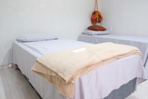 two beds in a room with a blanket at Refúgio Paraíso in Santo Amaro