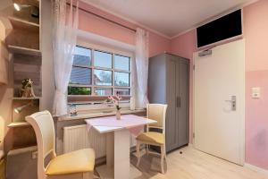 a dining room with a table and chairs and a window at Ferienwohnung Wencke in Büsum