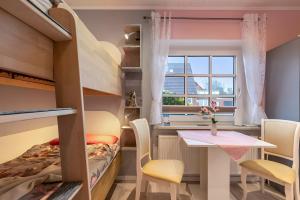 a room with a bunk bed and a table and chairs at Ferienwohnung Wencke in Büsum