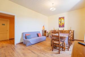a living room with a blue couch and a table at Gîte Le Chant Des Oiseaux in Pradons