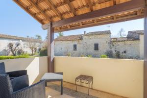 a patio with chairs and a view of a building at Gîte Le Chant Des Oiseaux in Pradons