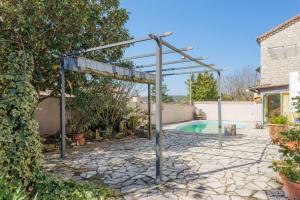 a pergola over a swimming pool in a yard at Gîte Le Chant Des Oiseaux in Pradons