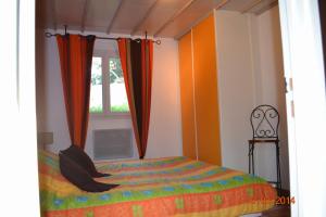 a bedroom with a bed and a window at Rez-de-villa Taglio-Isolaccio in Taglio-Isolaccio