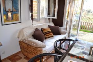 a living room with a white couch and a window at Rez-de-villa Taglio-Isolaccio in Taglio-Isolaccio