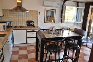 a kitchen with a table and some chairs in it at Rez-de-villa Taglio-Isolaccio in Taglio-Isolaccio