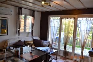 a living room with a couch and a table at Rez-de-villa Taglio-Isolaccio in Taglio-Isolaccio