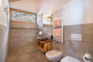 a bathroom with a white toilet and a sink at Eggerhof Familiennestl in Verano +15 photos