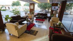 a lobby with couches and chairs and a large window at Jowharet AlMaseya in Al Khobar