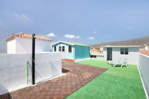 a backyard with green grass and white buildings at Los Morales in Arico