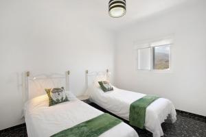 two beds in a room with white walls and a window at Los Morales in Arico