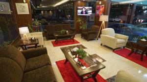a living room with couches and tables and a tv at Jowharet AlMaseya in Al Khobar