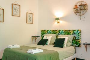 a bedroom with a bed with a green blanket at Chambre d'hote Emeraude in Genouillé +28 photos