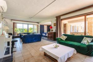 a living room with a green couch and a table at Chambre d'hote Emeraude in Genouillé