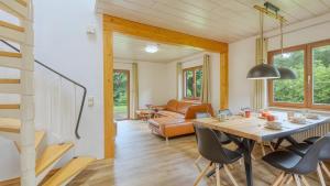 a dining room and living room with a table and chairs at Waldblick - Stilvolles Ferienhaus in Kemmerode +17 photos