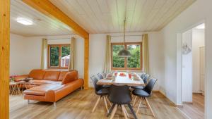 a living room with a table and a couch at Waldblick - Stilvolles Ferienhaus in Kemmerode