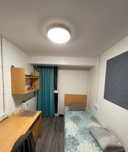a classroom with a desk and a bed in a room at Abez Accs in Portsmouth
