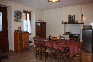 a kitchen with a table and chairs and a kitchen with a refrigerator at Maison La Picade in Saint-Mamet
