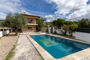 a swimming pool in front of a house at El Castillo in La Adrada