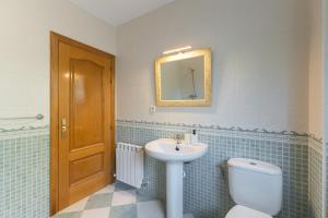 a bathroom with a sink and a toilet and a mirror at El Castillo in La Adrada +25 photos
